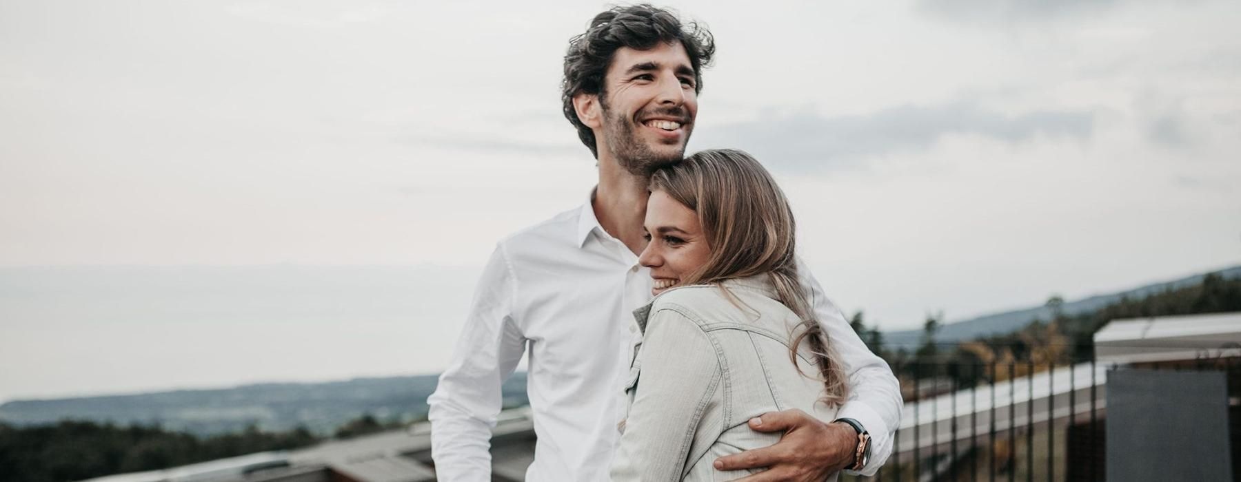 a man and woman hugging on rooftop terrace