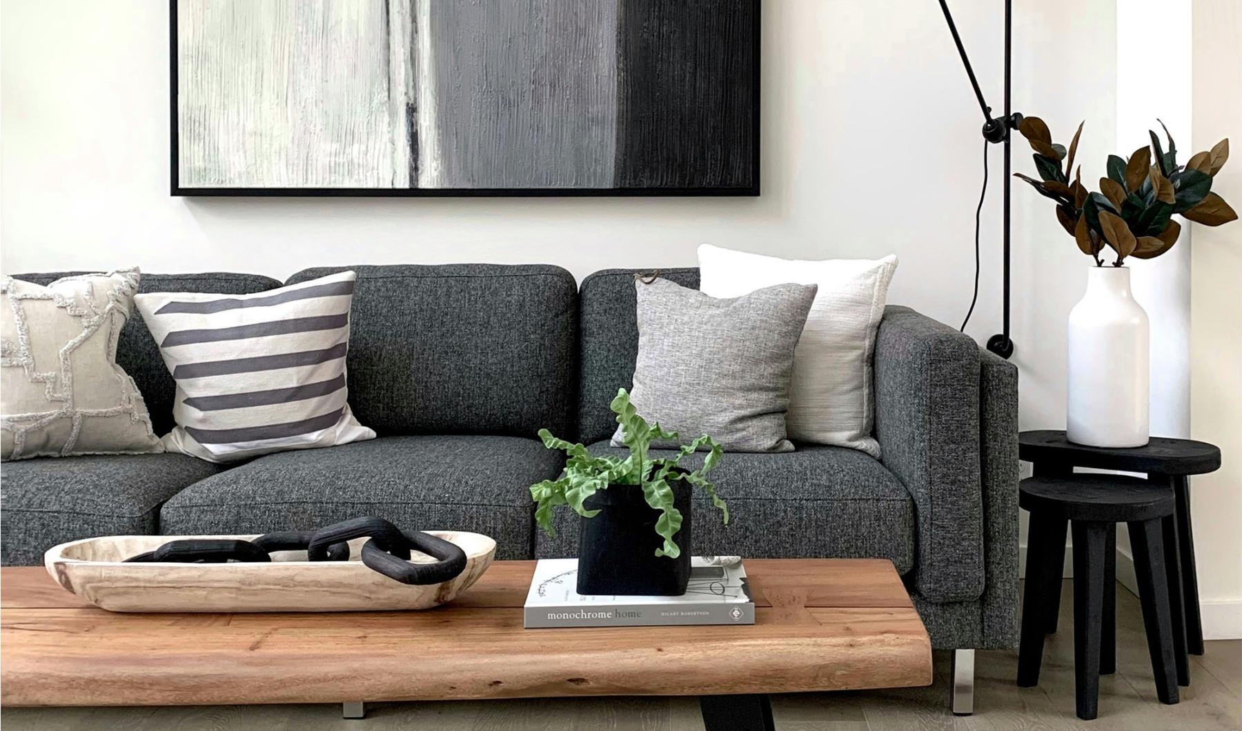 a couch with a coffee table with a plant and decor on it