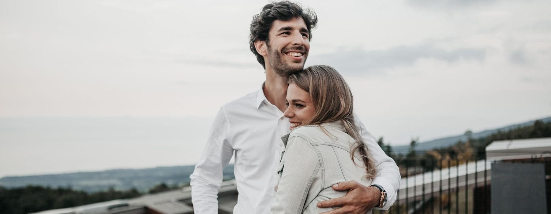 a man and woman hugging on rooftop terrace